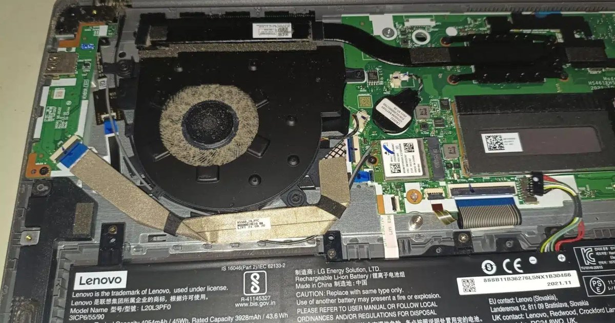 Interior de un portátil con ventilador y disipador antes de la limpieza y el cambio de pasta térmica