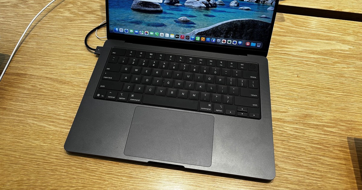 MacBook Pro de 14 pulgadas abierto sobre una mesa de madera
