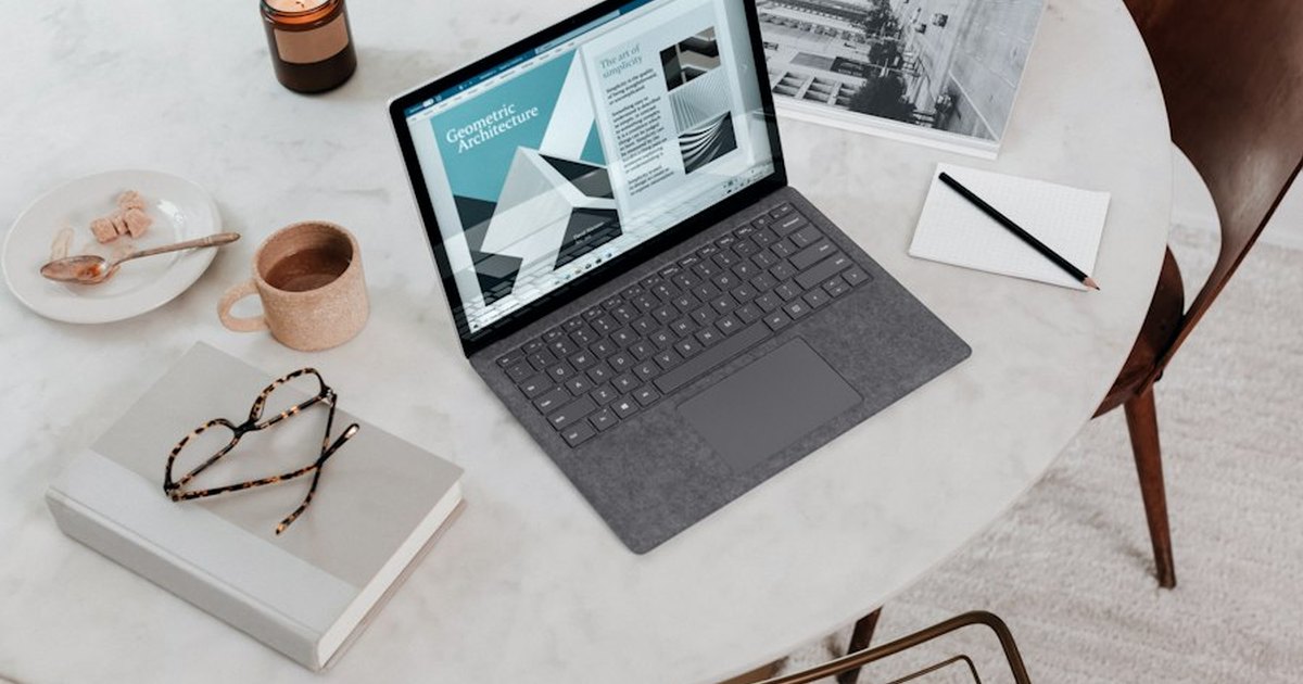Portátil abierto sobre una mesa de trabajo con documentos, uso para autónomos y pymes