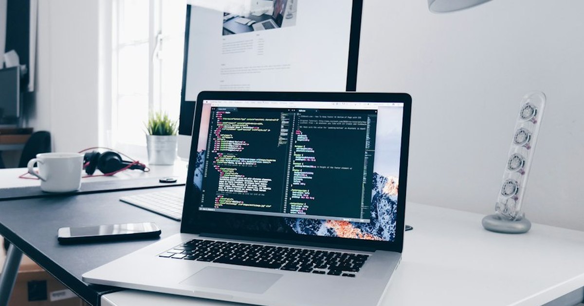 Portátil con código en pantalla sobre un escritorio de programador